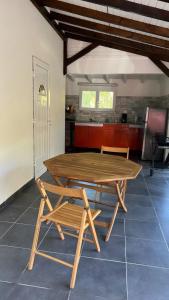 Una mesa y sillas de madera en una habitación. en BUNGALOW Terakota, en Deshaies