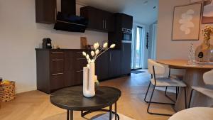 a living room with a table with a vase on it at Snoozz retreats in Haarle
