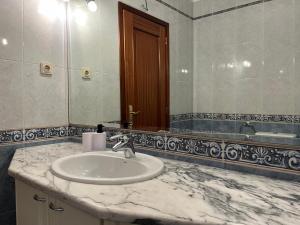 a bathroom with a sink and a mirror at Povoa Center Beach Apartment in Póvoa de Varzim