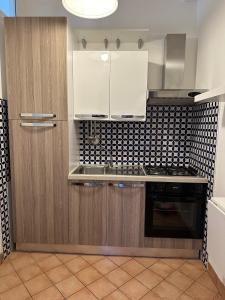a kitchen with white cabinets and a stove top oven at BOUGAINVILLEA Relax e Mare a 50m, in Centro! in Marina di Casalvelino +2 photos