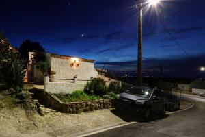 a car parked on the side of a street at night at Refúgio da Alma in Mafra
