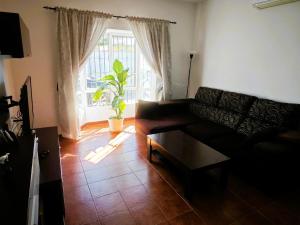 a living room with a couch and a table and a window at Chalet Familiar Relax con piscina in Chiclana de la Frontera
