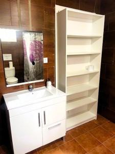 a bathroom with a white sink and a toilet at Chalet Familiar Relax con piscina in Chiclana de la Frontera
