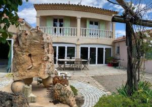 a house with a large rock in front of it at Gite LA FONTAINE Famille Amis Relais Motards in Peyriac-de-Mer