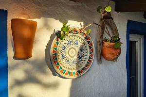 a plate hanging on a wall with potted plants at Refúgio da Alma in Mafra