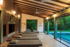 una fila de almohadas alineadas en una habitación con piscina en Neem Tree House en Kirinda