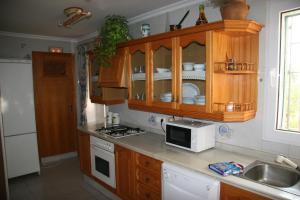 a kitchen with wooden cabinets and a counter top at casa rural Mas Pare Sant in Alcoy