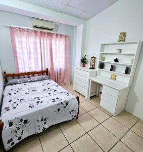 a bedroom with a bed and a white dresser at 3 bedroom townhouse in Diego Martin