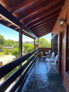 a patio with white chairs on a house at Depto Villa Gesell in Villa Gesell
