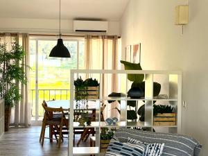 a living room with a table and a white shelf with plants at Casa do Mar -Sea house in Nazaré