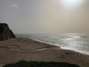 a group of people on a beach near the ocean at Refúgio da Alma in Mafra