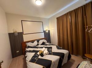 a hotel room with two beds and a window at Mon Amour Haven - 1BR Taytay Rizal in Taytay +27 photos