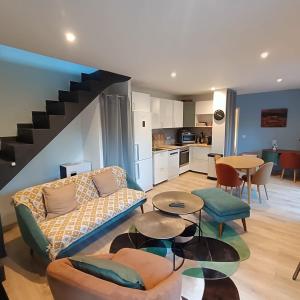 a living room with a couch and a table and a kitchen at Au sommet des Ocres et des Bois - Maison T3 & Parking in Roussillon