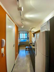 a small kitchen with a refrigerator and a bedroom at Estudio no Centro de Curitiba in Curitiba +15 photos