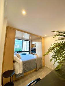 a bedroom with a bed and a large window at Estudio no Centro de Curitiba in Curitiba