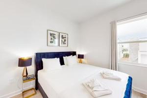 达文波特Luxury 4 BR Den w Private Pool close to Disney Golf Clubs Pet Friendly的卧室里有一张白色的大床和一扇窗户