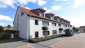 un grande edificio bianco con tetto rosso di Stilvolles Apartment mit Parkplatz, barrierefrei a Reinheim