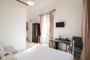 een slaapkamer met een bed, een bureau en een raam bij Domus Linda B&B in Ischia