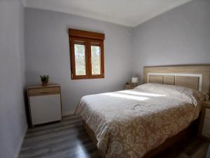 a bedroom with a bed and a window at Entrepinos in Guisando