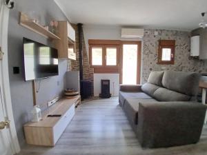 a living room with a couch and a flat screen tv at Entrepinos in Guisando