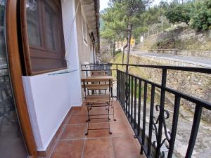 a balcony with two chairs and a railing at Entrepinos in Guisando