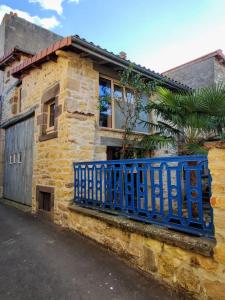 a blue fence on the side of a stone house at Chez Mathilde et Kévin in Saint-Maurice