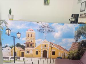 a mural of a yellow building with a church at Hotel Santa Bárbara in Mompos