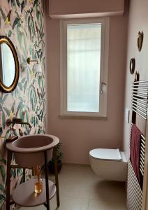 a bathroom with a sink and a toilet and a window at Baki B&B in Rimini