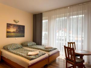 a bedroom with a bed and a table and a window at Pokoje Goscinne Zbojnik in Szczyrk