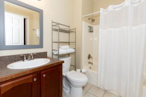 a bathroom with a toilet and a sink and a shower at The Jazz Club Downtown Sandusky in Sandusky