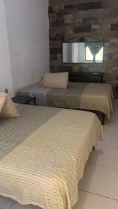 twee bedden in een kamer met een spiegel bij Hotel La Mansion del General in Tampico