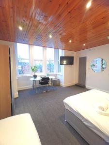 a bedroom with a bed and a desk with a tv at Claremont Hotel in Nottingham