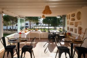 a dining room with tables and chairs and a large window at Heros Hotels Bozcaada in Bozcaada