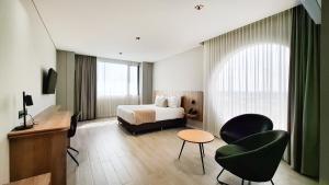 CaucasiaBotanico Hotel y Spa的一间带床、桌椅的酒店房间