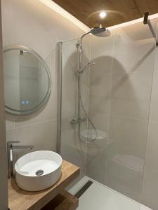 a bathroom with a shower with a sink and a mirror at Le Cro-Bidou in Bernex +33 photos
