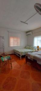 a room with two beds and two chairs in it at Tamarin Beach House in Tamarin