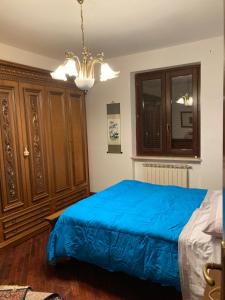 a bedroom with a blue bed and wooden cabinets at LA CASA FRA gli ULIVI UMBRA in Terni