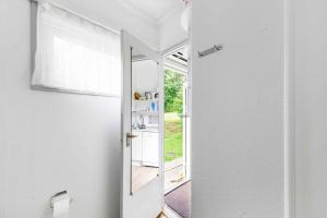 NeksøにあるCozy Holiday Apartment Close To The Beachの白いバスルーム(鏡、ドア付) +13枚の写真
