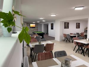 a restaurant with tables and chairs and a pool table at Pensiunea Royal Panzió in Praid