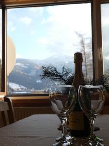 a table with two glasses and a bottle of wine at Forester Apartment Zuberec in Zuberec