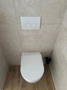 a bathroom with a white toilet in a room at Cheap Worker Apartment with Garden near Solarfields in Parndorf +15 photos