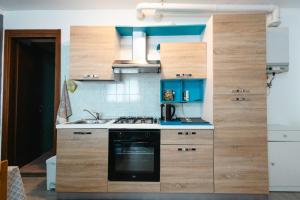 a kitchen with wooden cabinets and a stove top oven at Casa vacanza Miralago in Antronapiana +9 photos