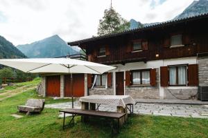 a picnic table with an umbrella in front of a building at Casa vacanza Miralago in Antronapiana