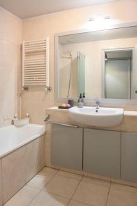 een badkamer met een wastafel, een bad en een spiegel bij Apartamento Mira Foz in Matosinhos