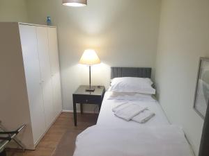 Schlafzimmer mit einem Bett und einer Lampe auf einem Tisch in der Unterkunft Spacious, Stylish Two-Bedroom Maisonette, Modern Amenities, Elegant Interiors in Buckinghamshire + 21 Fotos