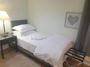 ein Schlafzimmer mit einem Bett und einem Schreibtisch mit einer Lampe in der Unterkunft Spacious, Stylish Two-Bedroom Maisonette, Modern Amenities, Elegant Interiors in Buckinghamshire