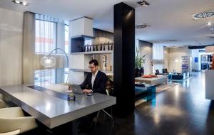 a man sitting at a table with a laptop at Hotel Sercotel Ciutat D'Alcoi in Alcoy