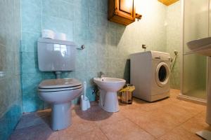 a bathroom with a toilet and a washing machine at Casa vacanza Miralago in Antronapiana