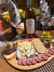 a plate of meats and cheese and a bottle of wine at Lago Amor de Valle Glamping in Villa de Juárez