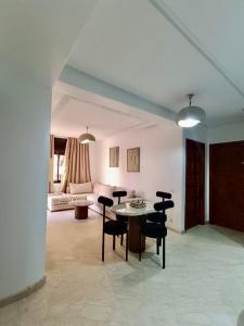 a living room with a table and chairs and a couch at Cosy appartement au cœur de Gueliz in Marrakech